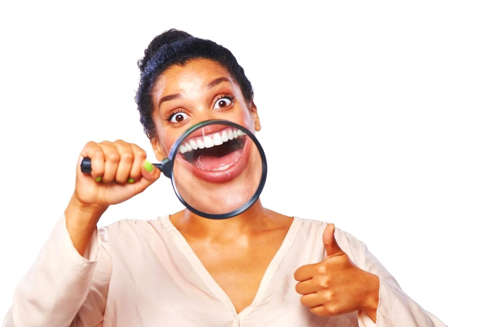 Woman examining her smile with a magnifying glass and giving a thumbs up